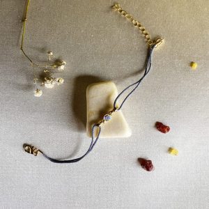 pulsera-brillante-en-hilo-azul-con-acero-inoxidable-dorado