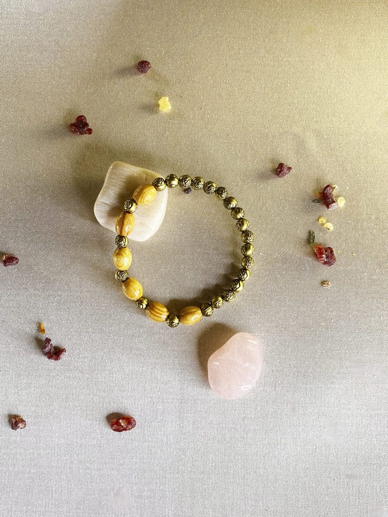 pulsera-de-madera-natural-y-cuentas-en-forma-de-rosa-doradas